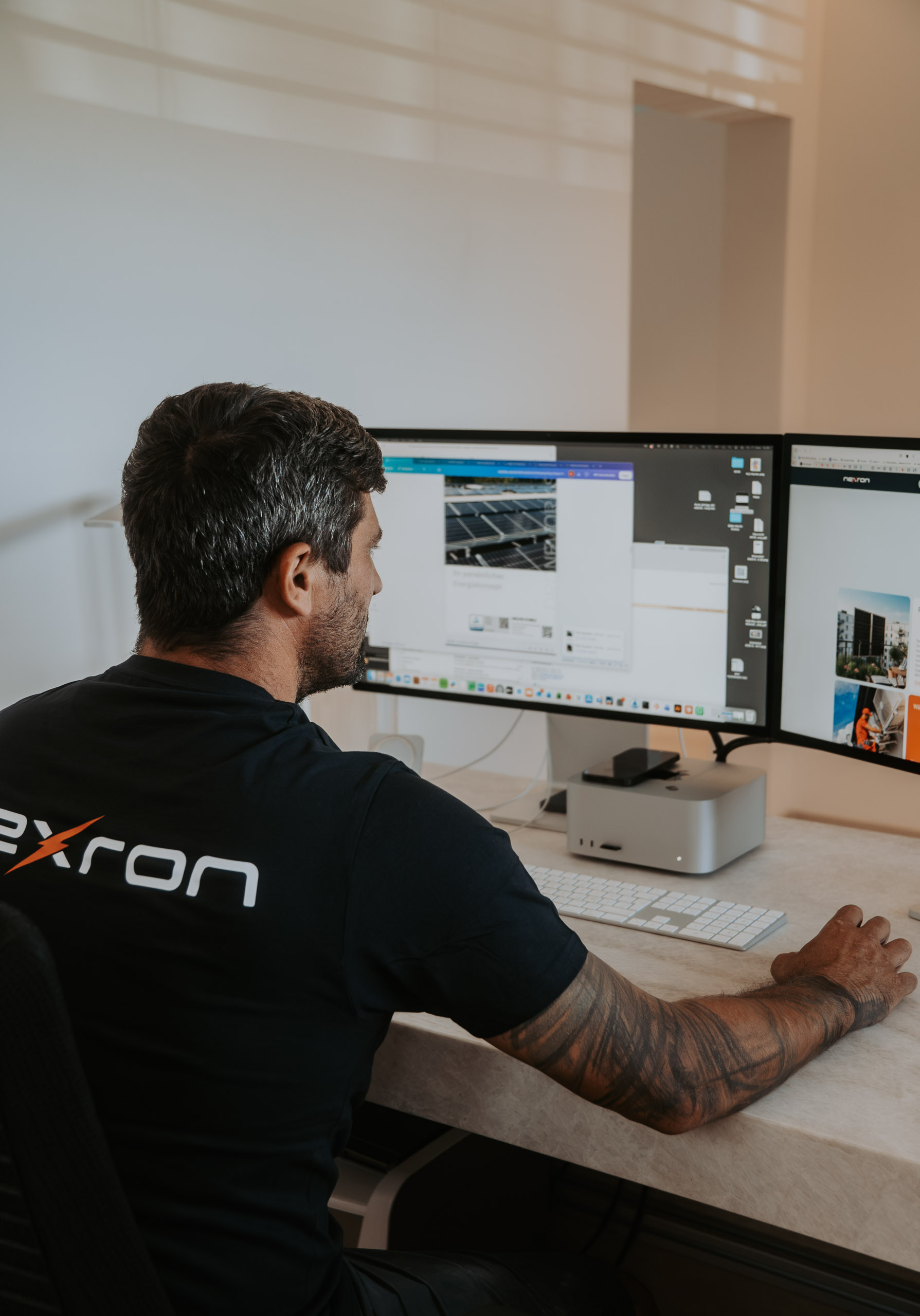 Nexron Mitarbeiter arbeitet am Schreibtisch mit zwei Monitoren und analysiert digitale Inhalte.